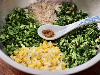 荠菜鸡蛋虾皮蒸包,盆中放入剁碎的荠菜和韭菜，炒熟的鸡蛋和淡干虾皮，先放入花椒粉增加口感。
