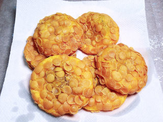 脆皮南瓜饼,大约炸6分钟左右，捞出玉米饼，放在吸油纸上吸去多余的油脂。