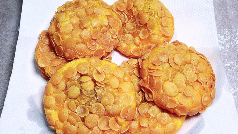 脆皮南瓜饼,大约炸6分钟左右，捞出玉米饼，放在吸油纸上吸去多余的油脂。