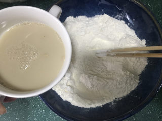玉米面窝窝头,用备好的温水把酵母化开，再倒入普通面粉中，搅拌均匀后放入面包桶
