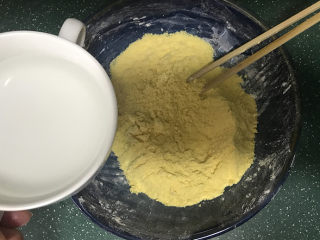 玉米面窝窝头,将备好的开水，慢慢地倒入玉米面粉中，搅拌均匀稍凉后也倒入面包桶