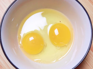 南瓜鸡蛋羹,准备两个鸡蛋打入碗中。