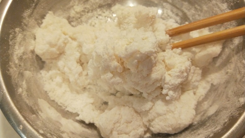 糯米蛋黄芝麻饼,开水合面，用筷子搅拌成面团，稍微凉一下。