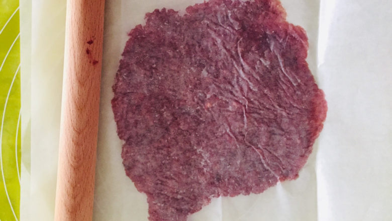 蜜汁猪肉脯,取油纸对折，肉泥放在两张油纸中间，并用擀面杖擀成薄饼