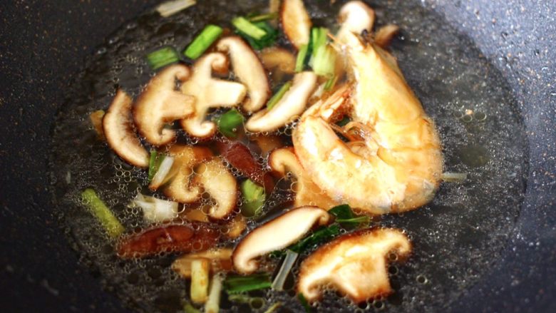 鲍鱼对虾香菇菠菜面,大火翻炒均匀后，倒入煮鲍鱼的汤汁和对虾。