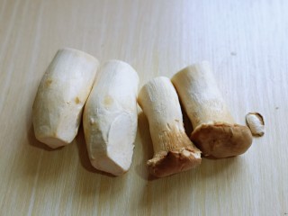 孜然蘑菇,首先将杏鲍菇洗干净，从中间切开，一切二。