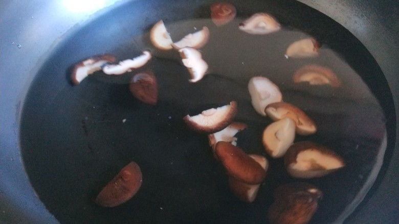 青菜炒香菇,锅中水烧开倒入香菇煮熟。