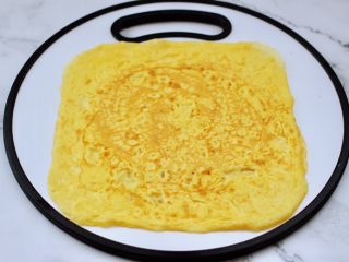双色如意卷（年夜饭必备）,把煎好的鸡蛋饼，平铺在菜板上。