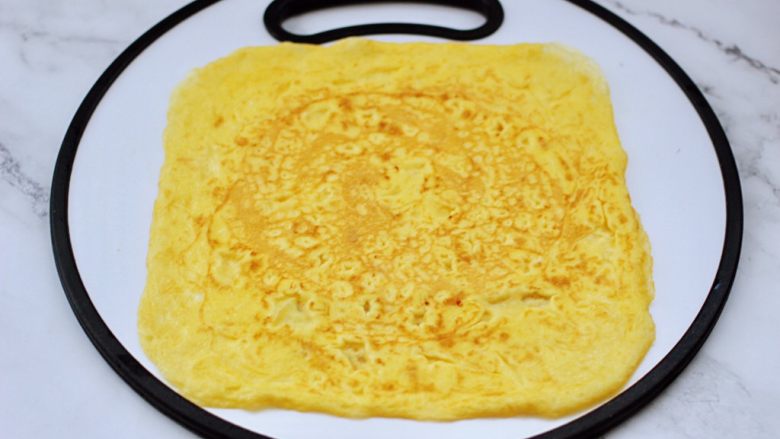 双色如意卷（年夜饭必备）,把煎好的鸡蛋饼，平铺在菜板上。