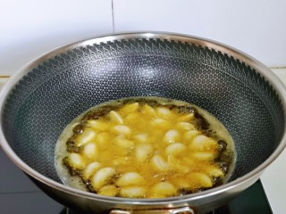葱爆羊肉片,起油锅，油温6成热时加入蒜瓣。
