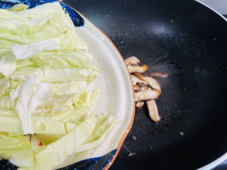 鸡蛋炒年糕,锅中留底油入香菇和卷心菜