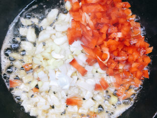 花开富贵椒盐虾,倒入姜蒜末、大葱末和彩椒粒。