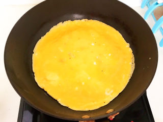 鸡蛋炒年糕,鸡蛋液凝固后拿起炒锅晃一晃，让鸡蛋液受热均匀