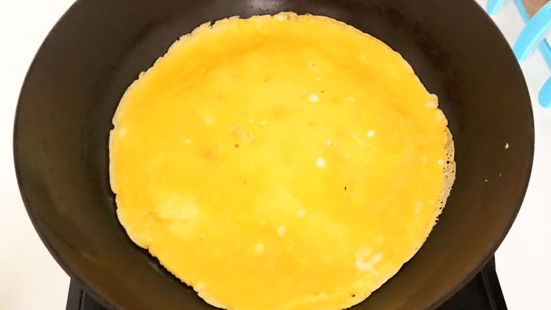 鸡蛋炒年糕,鸡蛋液凝固后拿起炒锅晃一晃，让鸡蛋液受热均匀