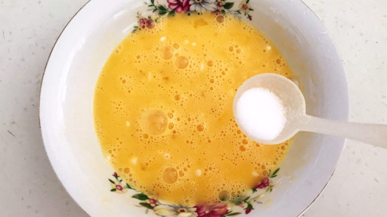鸡蛋炒年糕,鸡蛋打入大碗里，加入精盐调匀