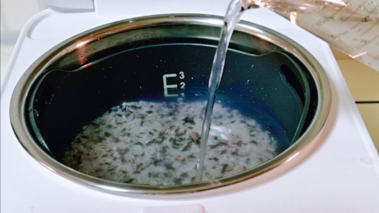 黑米红豆粥,掏干净的米倒入饭煲中，再加入纯净水，水量根据用米的量来。