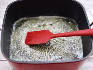 芝麻核桃糖,把融化好的黄油，均匀地摇匀整个锅底。
