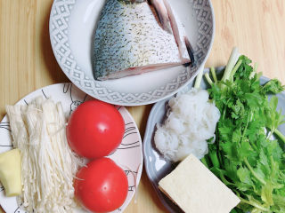 砂锅鱼头煲,准备好食材。鱼头、豆腐、魔芋粉、香芹芯、金针菇、番茄、豆腐、葱姜、香菜。