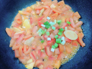 砂锅鱼头煲,加入葱花翻炒均匀。