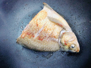 砂锅鱼头煲,将鱼头翻面，继续煎至另一面也为金黄色。取出鱼头。