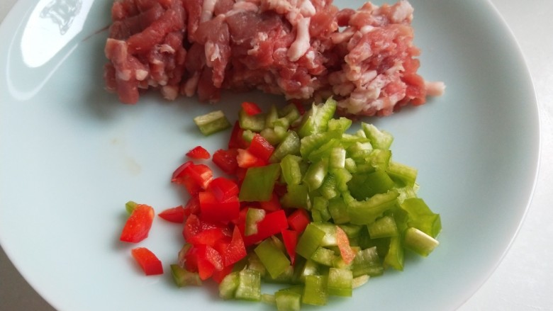 粉条炒肉,解冻好用够量的肉馅装盘，青红椒切丁。