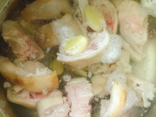 黄豆焖猪蹄,锅中烧水，放入4片生姜、料酒汆水5分钟