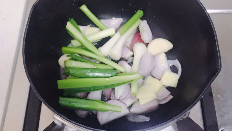 砂锅鱼头煲,放入葱头蒜头姜片蒜苗爆香。