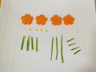 芝士面包片,胡萝卜片用模具刻出花朵形状，从芝士片上用细吸管刻出四个小圆片做花心，用黄瓜皮剪出小花的枝干、叶子和小草。