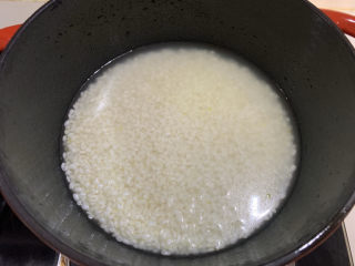 腊味煲仔饭,大米淘净浸泡一小时，锅底刷油后放入，加漫过米一点点的水量，中火煮饭