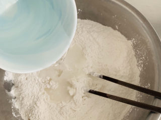 红豆汤圆,面粉的吸水量不一样，请先预留10克。
将水倒入糯米粉中，用筷子搅拌。
