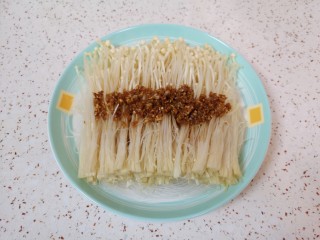 粉丝蒸金针菇,将炒好的蒜末汤汁浇在金针菇上面。