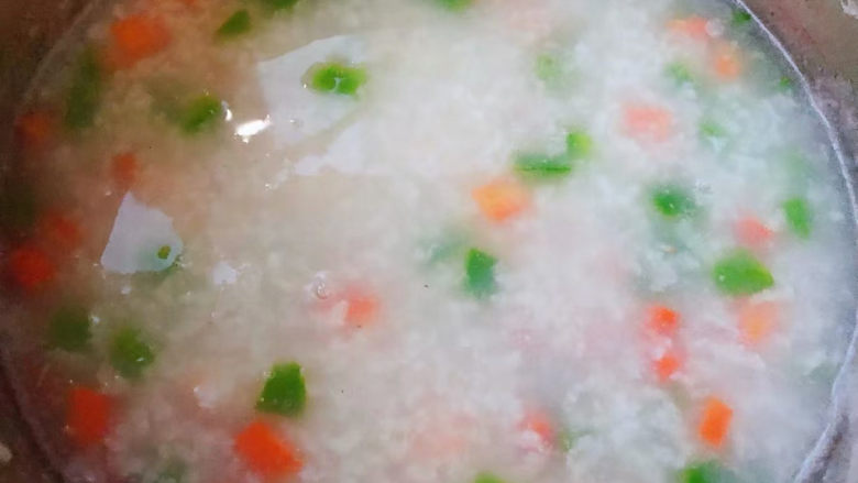 蔬菜虾仁粥,放入青椒和胡萝卜粒中火煮2分钟