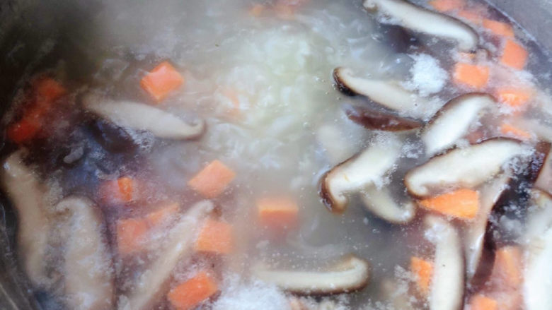 香菇排骨粥,放入香菇和胡萝卜中小火煮三分钟