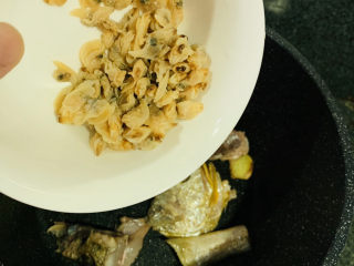 砂锅鱼头煲,鱼头煎的金黄，蒜头和姜煎黄，即可加入蛤蜊干煸炒；
