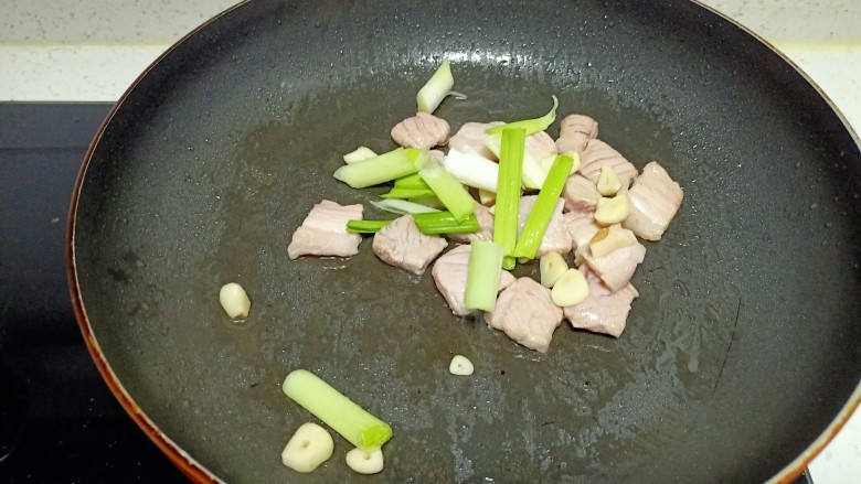 猪肉炒胡萝卜、蒜苔,放入蒜苗根和蒜片