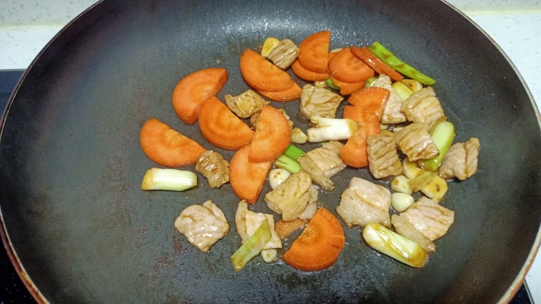 猪肉炒胡萝卜、蒜苔,放入胡萝卜
