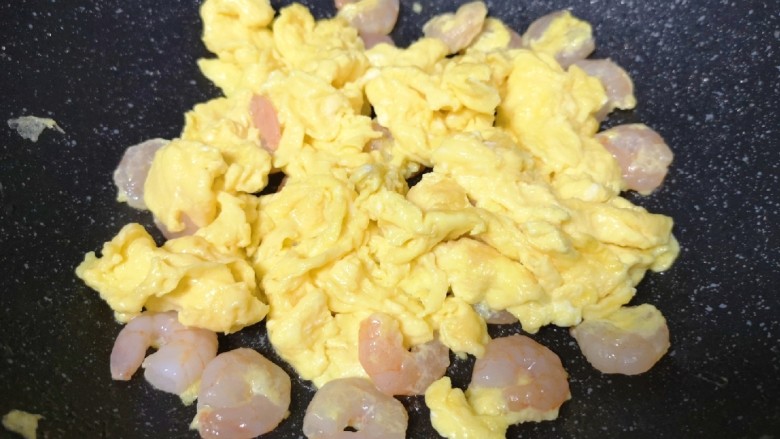虾仁跑蛋,调中火，用筷子翻动至蛋液凝固。