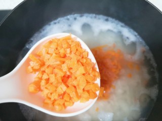 蔬菜虾仁粥,锅开以后下入胡萝卜丁。