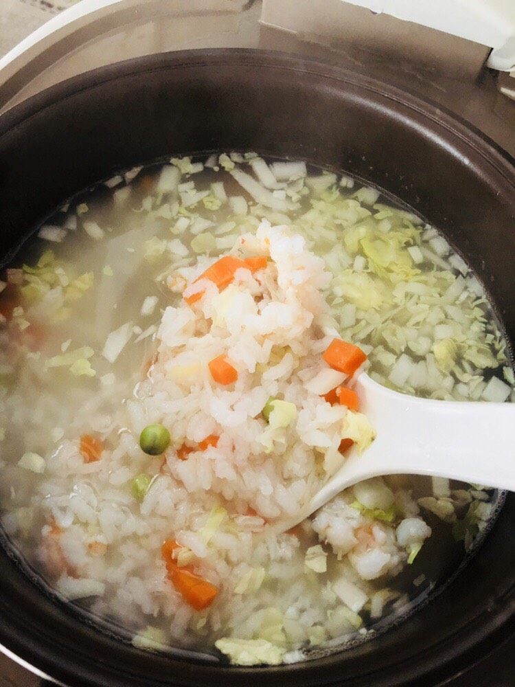 蔬菜虾仁粥（2-3人份）,煮四十分钟左右放入虾仁和干贝，用勺子搅拌均匀