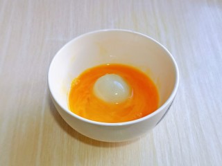 油炸汤圆,夹一个汤圆放入蛋液中，裹上蛋液。