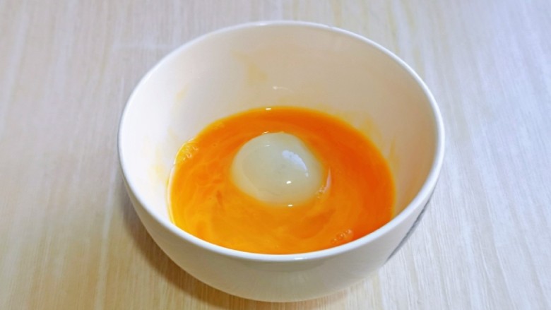 油炸汤圆,夹一个汤圆放入蛋液中，裹上蛋液。