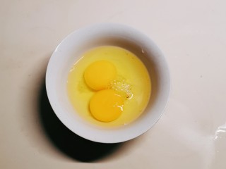 腊肠炒鸡蛋,鸡蛋敲入碗中
