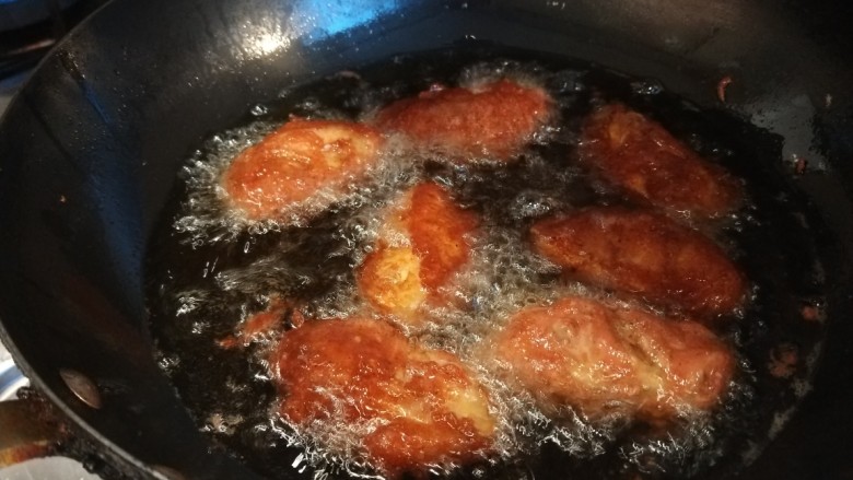 薯片鸡翅,下油锅炸制金黄捞出来。