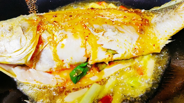 红烧黄鱼,两面煎好后放入一勺辣油，并将葱姜蒜倒入爆香