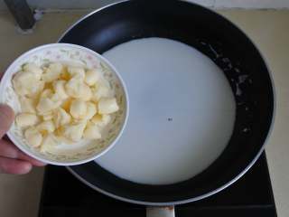 奶酪汁欧芹细面,平底锅内倒入牛奶，放奶酪粒加热至融化