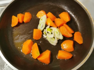 牛腩萝卜汤,炒锅放入食用油  油热后放入胡萝卜块 翻炒3分钟 放入葱片关火