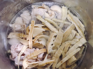 笋干老鸭汤,把焯过水的鸭肉和笋加适量水放进电压锅，选择煲汤键
