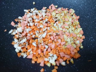 玉米面糊糊,不粘锅内倒少许食用油烧热，下入香菇、胡萝卜、豆腐干和火腿肠。