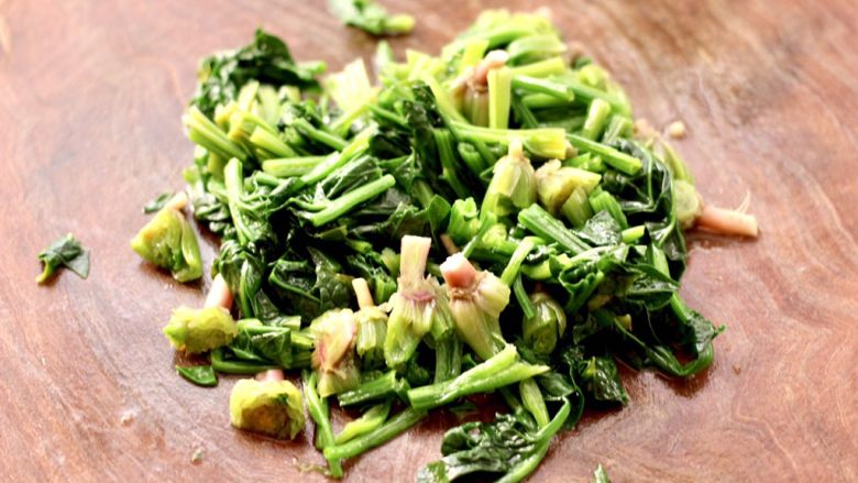 花生米拌红根菠菜,把焯烫的菠菜用刀切成小段。