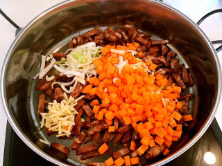 香菇腊肠焖饭,加入葱姜和胡萝卜，翻炒均匀